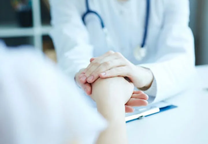 A physician holding a patient's hand during an endometriosis consultation at Academia Women's Health
